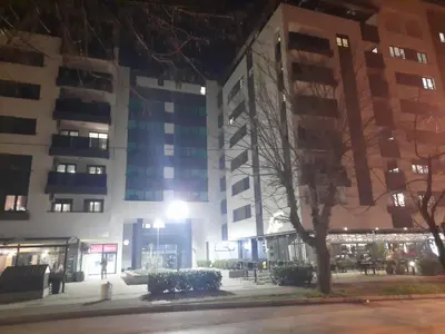 a building at night with a tree in front of it at Apartman Stepe Stepanovica in Banja Luka
