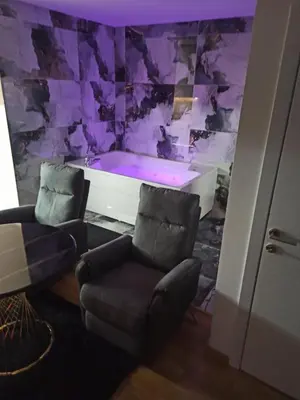 a room with a bath tub and a chair at Spa centar Doboj in Doboj