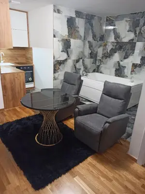 a living room with a table and two chairs and a tub at Spa centar Doboj in Doboj