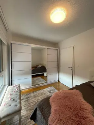 a bedroom with a bed and a large mirror at Apartman Sisters in Sanski most