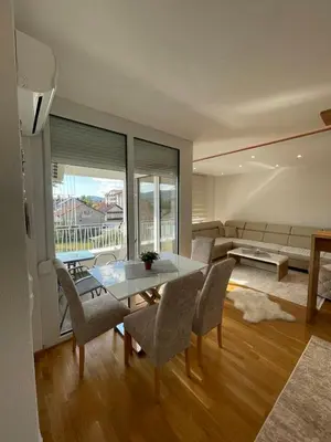 a living room with a table and chairs and a couch at Apartman Sisters in Sanski most