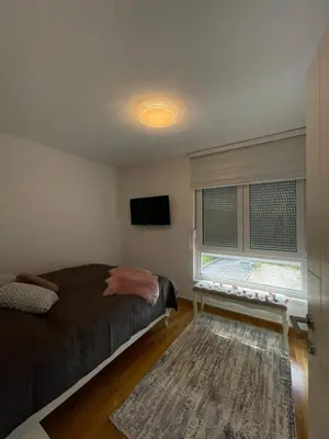 a bedroom with a bed and a television and a window at Apartman Sisters in Sanski most