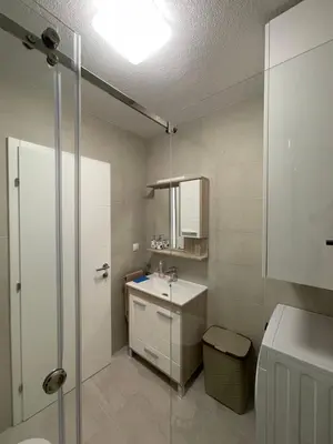 a bathroom with a sink and a shower and a toilet at Apartman Sisters in Sanski most