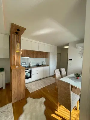 a kitchen and dining room with a table and chairs at Apartman Sisters in Sanski most