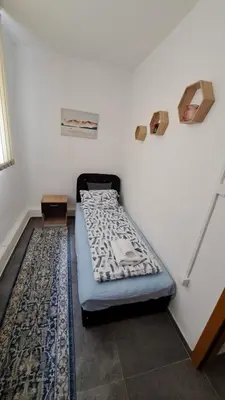 a bed sitting in a corner of a room at Elita Prenoćište in Bihać