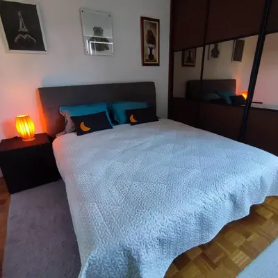 a bedroom with a large bed with a blue comforter at Apartment Wolf in Novi Travnik