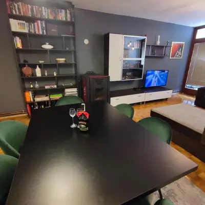 a black table with green chairs in a living room at Apartment Wolf in Novi Travnik