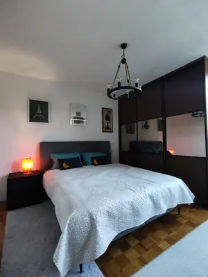 a bedroom with a large bed and a chandelier at Apartment Wolf in Novi Travnik