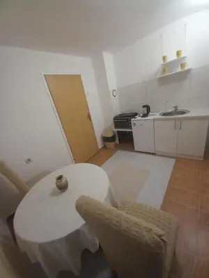 a white kitchen with a table and a sink at Apartman Dujaković in Banja Vrućica