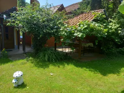 a stuffed animal sitting in the grass in front of a house at Apartman Dujaković in Banja Vrućica