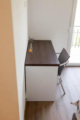 a desk in a room with a chair and a table at Apartmani Mia in Prozor