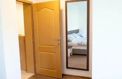a door to a bedroom with a bed and a mirror at Apartmani Mia in Prozor