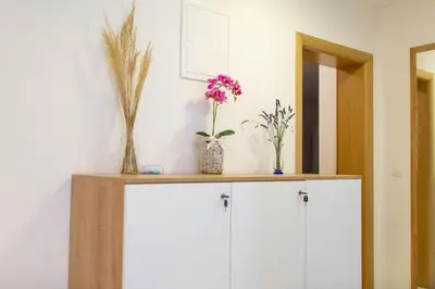 a cabinet with vases and flowers on top of it at Apartmani Mia in Prozor