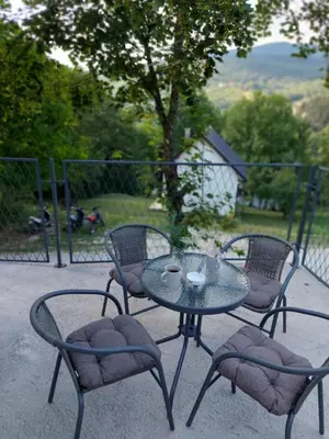 a glass table with two chairs and two cups on it at Apartman Emanuel in Jajce