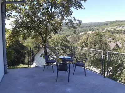 a table and chairs on a balcony with a view at Apartman Emanuel in Jajce