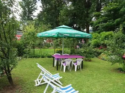 a purple table and chairs under a green umbrella at Apartman Dalal - with access to river Una in Bihać