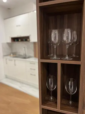 a shelf with wine glasses in a kitchen at Apartman Square Trg Prijedor in Prijedor