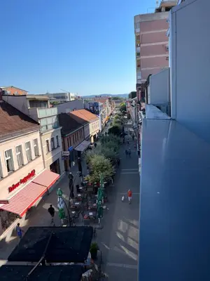a view of a city street with tables and buildings at Apartman Square Trg Prijedor in Prijedor
