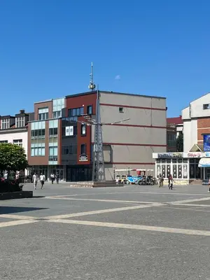 a city street with people walking in front of a building at Apartman Square Trg Prijedor in Prijedor