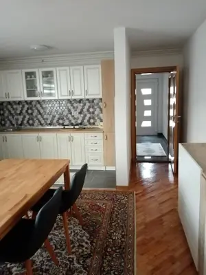 a kitchen with white cabinets and a wooden table at Azra in Visoko