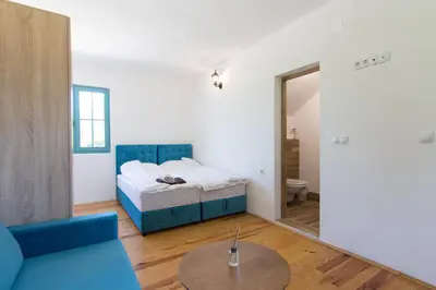 a living room with a bed and a table at Retro Village Ravne in Visoko