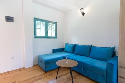 a blue couch in a living room with a table at Retro Village Ravne in Visoko