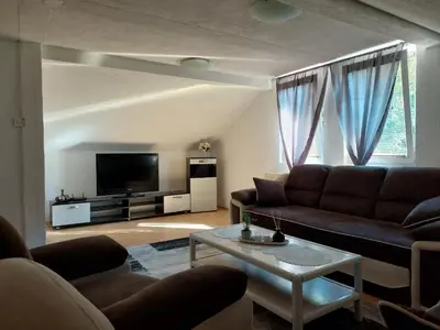 a living room with a couch and a tv at Apartment EM 2 in Tuzla