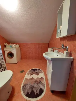 a bathroom with a sink and a washing machine at Apartment EM 2 in Tuzla