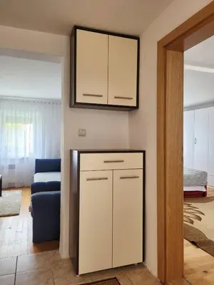 a living room with a cabinet and a blue couch at Kuća Mandić in Bosanska Gradiška
