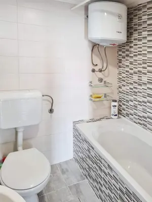 a bathroom with a toilet and a bath tub at Kuća Mandić in Bosanska Gradiška