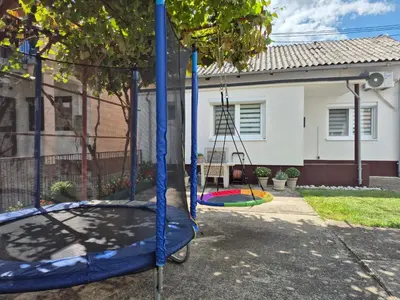 a swing set in front of a house at Kuća Mandić in Bosanska Gradiška