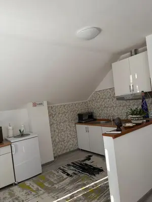 a kitchen with white cabinets and a ceiling at Apartman Salus in Tuzla