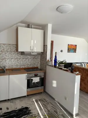 a kitchen with white cabinets and a stove at Apartman Salus in Tuzla