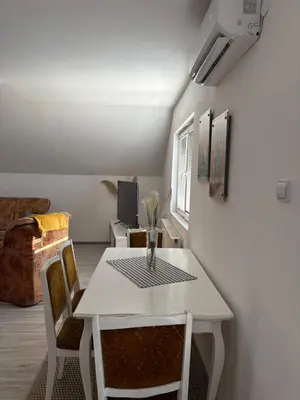 a dining room with a white table and chairs at Apartman Salus in Tuzla