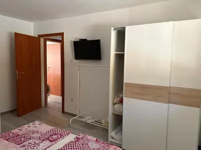 a room with a white cabinet and a tv on a wall at Apartman Salus in Tuzla