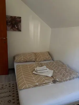 a unmade bed with a book on top of it at Apartman Salus in Tuzla