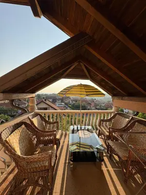 a patio with chairs and a table and an umbrella at Apartman Salus in Tuzla