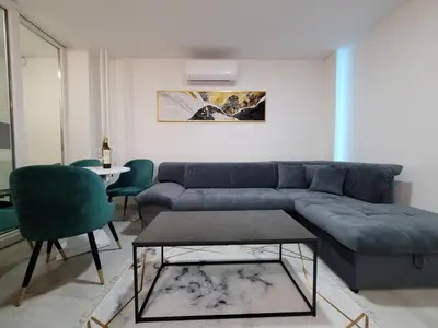 a living room with a blue couch and a table at Stan m&s, Boulevard-centar grada in Banja Luka
