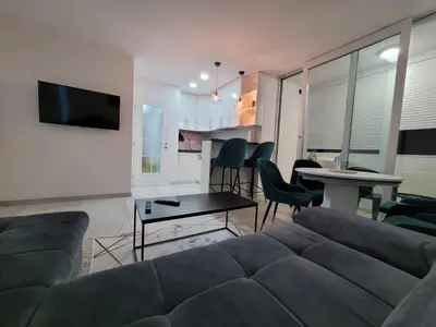 a living room with a couch and a table at Stan m&s, Boulevard-centar grada in Banja Luka