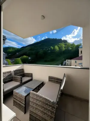 a balcony with two chairs and a large window at Valley of Pyramids Residence in Visoko