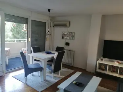 a living room with a table and chairs and a television at HomeB&E in Tuzla