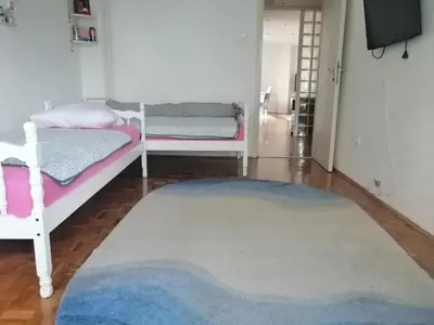 a bedroom with two beds and a rug at HomeB&E in Tuzla