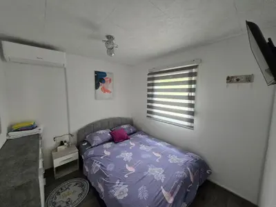 a bedroom with a bed with a purple comforter and a window at Vikendica SUNCE in Banja Luka