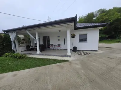 a white house with a porch and a patio at Vikendica SUNCE in Banja Luka