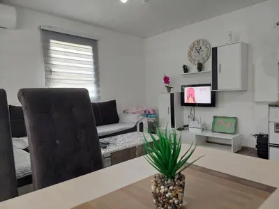 a living room with a table and a couch and a television at Vikendica SUNCE in Banja Luka