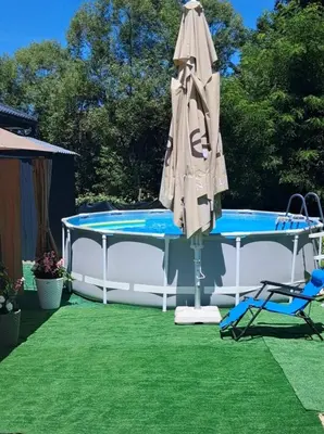 an umbrella and a table and a pool at Vikendica SUNCE in Banja Luka