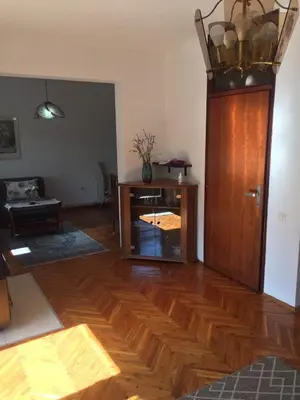 a living room with a wooden floor and a wooden cabinet at Studio apartman NINA in Bihać