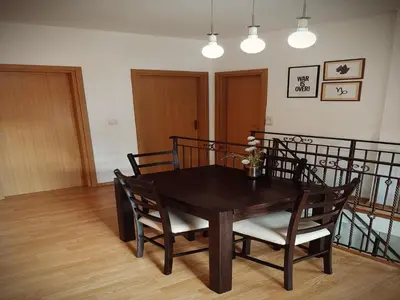 a dining room table and chairs with flowers on it at Old School Apartments in Banja Luka