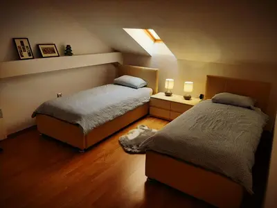 a bedroom with two beds and two lights on the wall at Old School Apartments in Banja Luka