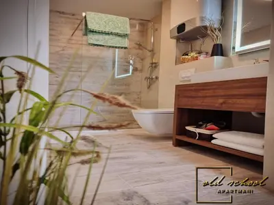 a bathroom with a tub and a toilet and a sink at Old School Apartments in Banja Luka